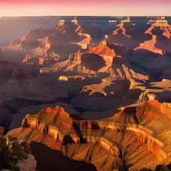Panoramic view of the Grand Canyon at sunrise with a hiker on the South Rim.